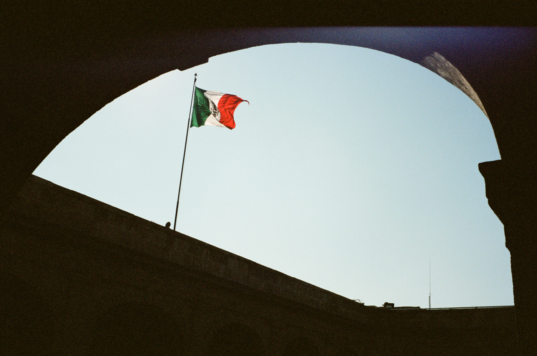 Mexican flag framed by a building